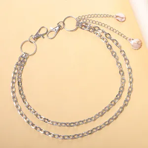 Détail d'une chaîne de pantalon multicouche argentée avec pendentifs en coquillage