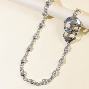 Détail d'une chaîne de pantalon punk argentée avec petits crânes et grand pendentif crâne