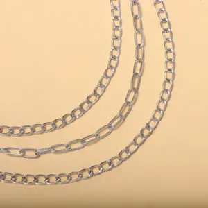 Detailansicht mehrlagiger silberner Metallketten in verschiedenen Gliederstilen