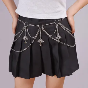 Detail of silver layered metal waist chain featuring cross pendants on a black skirt
