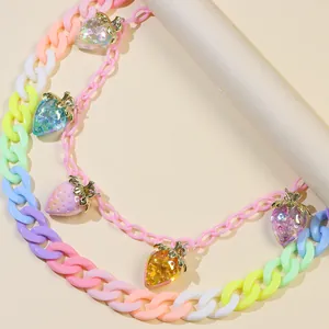 Détail de pendentifs fraises en acrylique sur une chaîne de pantalon multicouche style Y2K
