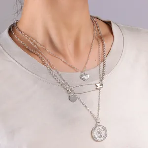 Collana a strati argentata con ciondolo a cuore e moneta vintage indossata da modella