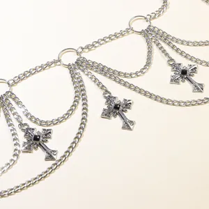 Detail of gothic multi-layer silver metal waist chain with ornate cross pendants