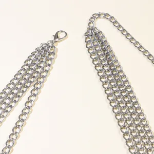 Detail of silver multi-layer metal waist chain featuring clasp and oval ring link design