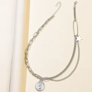 Dettaglio di collana argento multistrato con ciondoli a stella e moneta