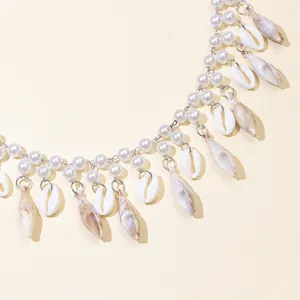 Detail of bohemian shell and pearl bag chain featuring starfish and conch pendants