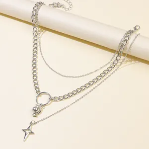 Dettaglio di collana a strati d'argento con ciondoli a globo e stella sul supporto