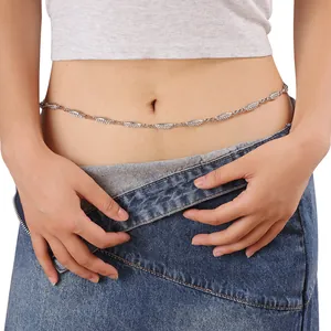 Detalle de cinturón de cadena plateada con pedrería en forma de marquesa sobre jeans