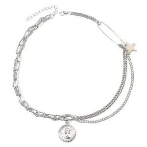 Dettaglio collana a strati in argento con ciondoli a stella e moneta della regina
