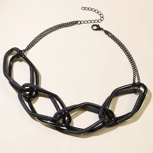 Dettaglio della collana nera spessa con trame a rete lucide e opache e chiusura a moschettone