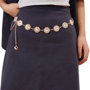 Detail of sunflower metal waist chain with sparkling crystals on dark dress fabric