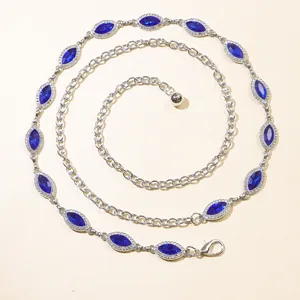 Detalle de la cadena de cinturón plateada con diamantes de imitación azul oscuro