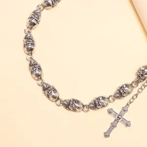 Close-up of gothic silver skull chain and retro cross pendant with embossed details