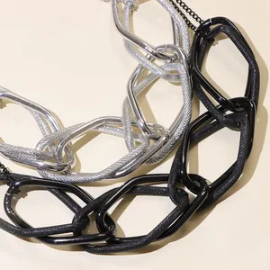 Dettaglio ravvicinato della collana punk con maglie argentate e nere strutturate