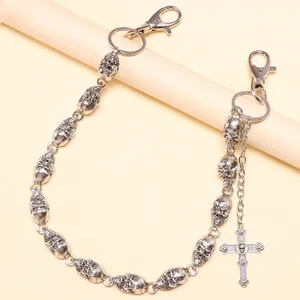 Close-up of punk style silver skull chain with cross pendant and lobster clasps on a prop