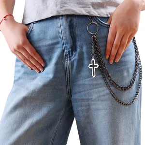 Detail view of punk rock multi-layer metal pants chain with cross pendant on jeans