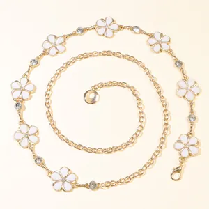 Close-up of golden sunflower waist chain with white enamel flowers and shiny rhinestones