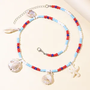 Bohemian colorful bead necklace set with sea shells and starfish pendants on a soft background