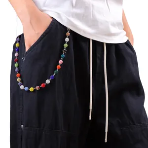 Vista macro di perline colorate con strass appese a pantaloni casual neri alla moda
