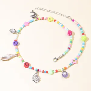 Detail of bohemian colorful beaded necklace with sea shell dolphin and flower charms