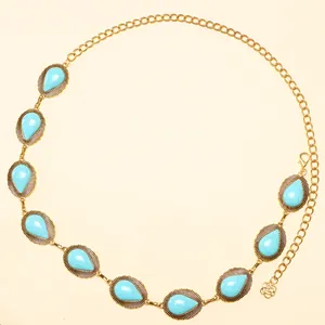 Detail of vintage golden waist chain with turquoise stones and rose pendant