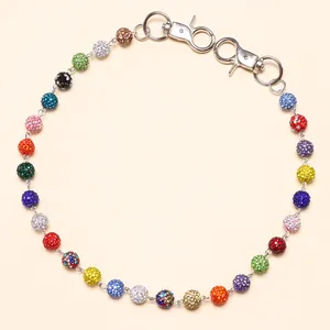 Dettaglio ravvicinato di una catena con strass colorati e chiusure a moschettone in metallo