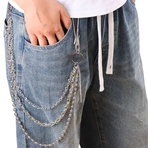 Détail de chaînes de pantalon multicouches en métal punk sur un jean avec crochets argentés