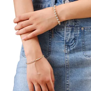 Detail of adjustable golden tennis bracelet with round clear cubic zirconia on model