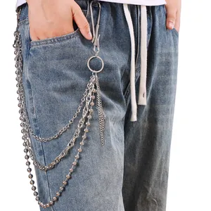 Détail d'une chaîne de pantalon punk à trois niveaux en métal sur un jean bleu