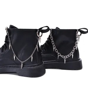 Schwarze 8-Loch Punk Martin Boots mit silbernen Metallketten und spitzen Anhängern auf Weiß