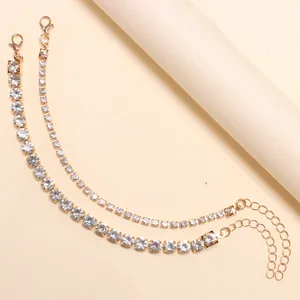 Close-up of adjustable gold-plated rhinestone chains with lobster clasps and extenders