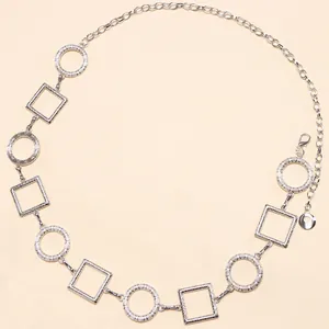 Detail van zilveren riem met geometrische ringen, textuur en verstelbare karabijnsluiting
