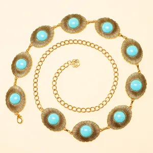 Détail de chaîne de taille bohème en métal avec incrustations de turquoise et breloques dorées