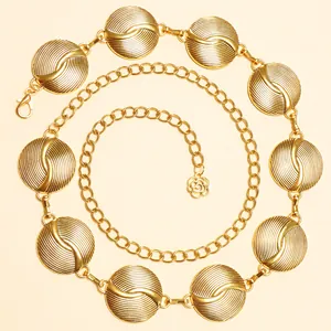 Détail de la chaîne de taille dorée avec disques texturés et pendentif rose élégant