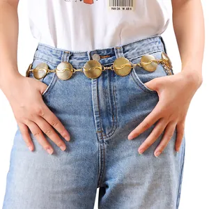 Chaîne de taille bohème en métal doré avec disques turquoise sur jean en denim bleu
