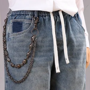 Double-layer hip-hop metal trouser chain with skull charms on blue washed jeans