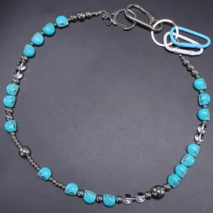 Detail van kralen broekketting met turquoise schedels, agaat en blauwe D-ring karabijn