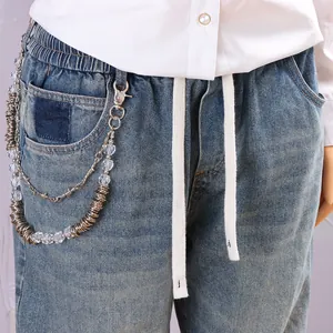 Detail of punk style pants chain with metallic silver thorns and acrylic beads