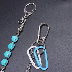 Detailopname van blauwe schedelkralen en metalen sluitingen aan een trendy broekketting