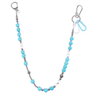 Broekketting met blauwe turquoise schedels en zilveren kralen op witte achtergrond