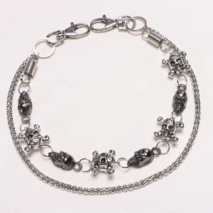 Detail of gunmetal punk trousers chain with skulls, spring charms and lobster clasps