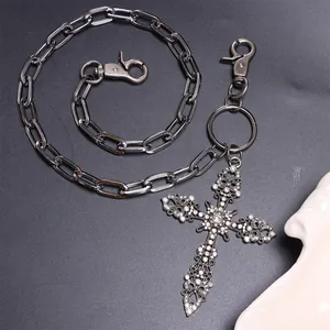 Makroaufnahme der silbernen Hosenkette mit einem glitzernden Strass-Kreuzanhänger