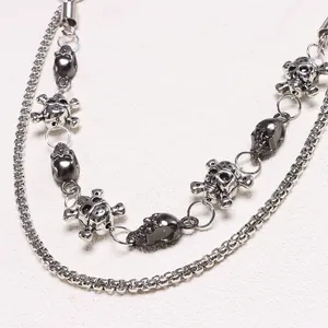 Detail of silver skull pendants on multilayered punk metal wallet chain with heavy links