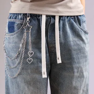 Détail d'une chaîne de pantalon argentée multicouche avec crochet étoile et pendentif cœur