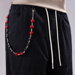 Detalle de cadena gótica para pantalón con cuentas de corazón rojas y negras en pantalón