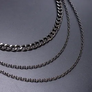 Detalle de cadenas multicapa gris oscuro con eslabones cubanos de estilo punk y hip hop