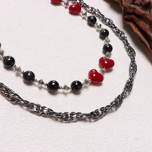 Detalle de cadena gótica para pantalón con corazones rojos, cuentas negras y eslabones