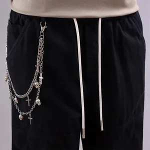 Close-up of hip-hop silver skull and cross pendant chains on black cargo pants waist