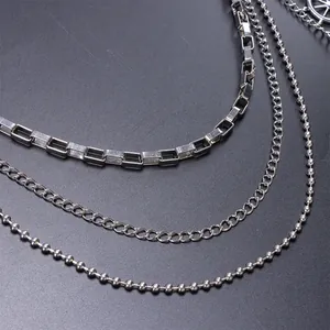 Detail of silver multi-layer metal pants chain with rectangular, curb, and bead link textures
