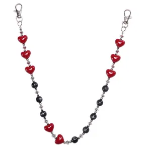 Detalle de cadena de pantalón gótica con cuentas de corazón rojo y piedras ojo de gato